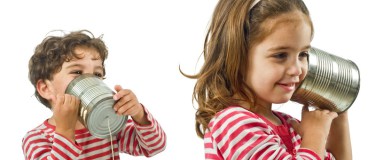 happy siblings talking to each other on tin can telephone